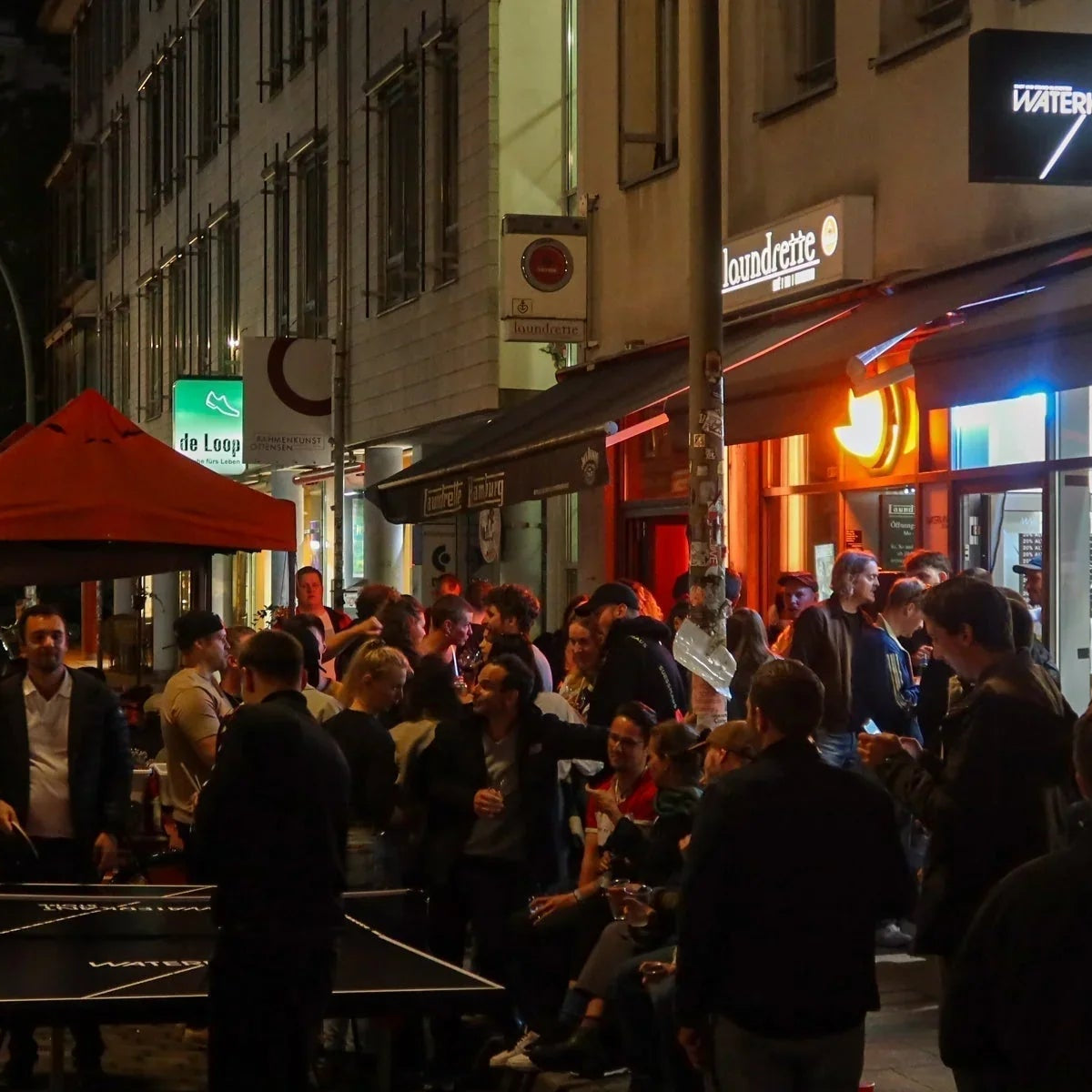 Menschenmenge vor dem WATERKANT Store während der Altonale in Hamburg bei Nacht.
